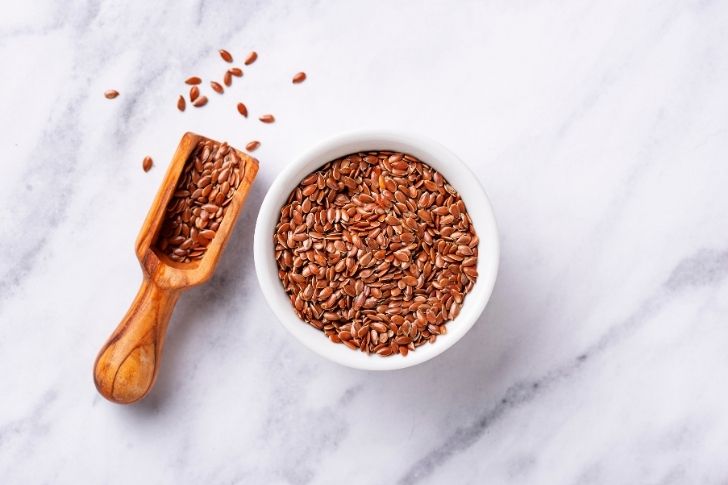 Flaxseed in a bowl on a white table.