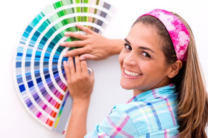 Woman with a color wheel to decorate with 60-30-10 rule.